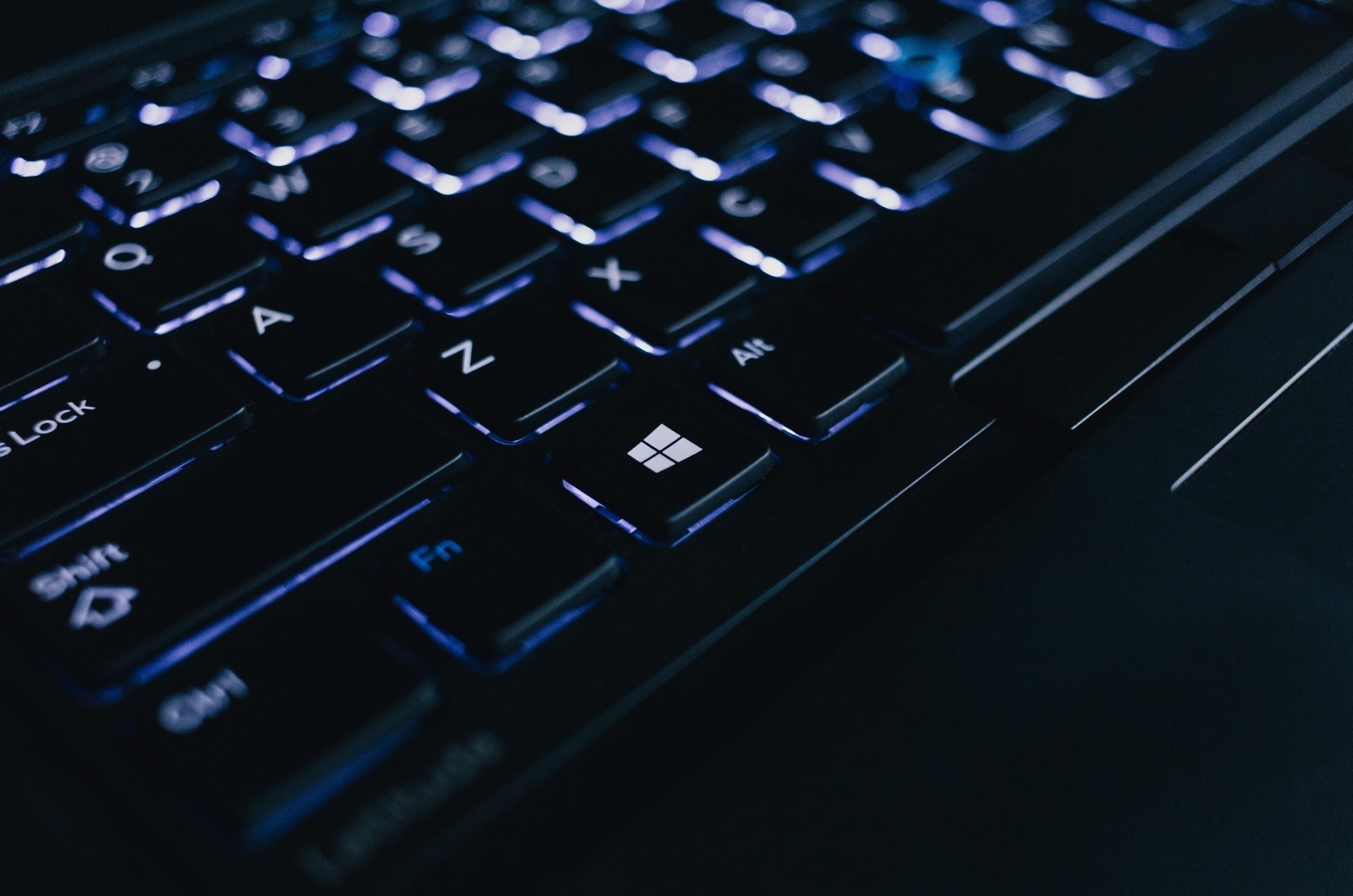 black laptop keyboard with white LED backlighting